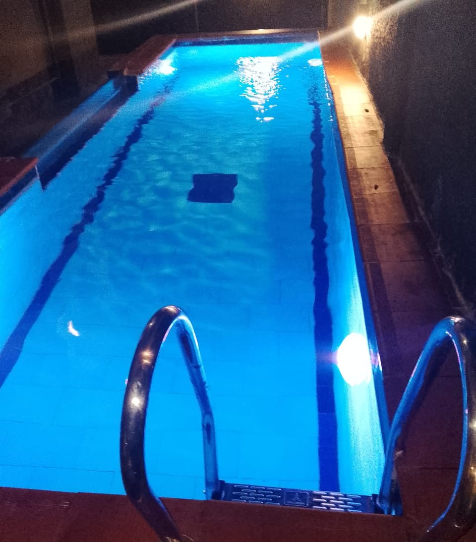 Rooftop swimming pool at a managed residential facility, evening